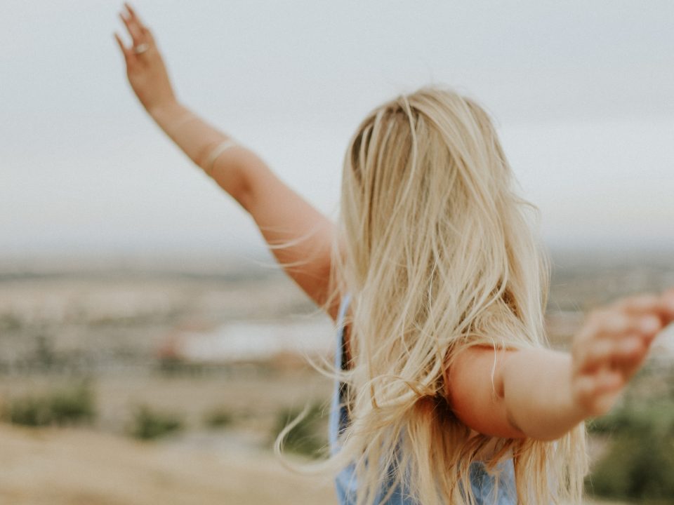 woman wearing blue top while standing on plain field