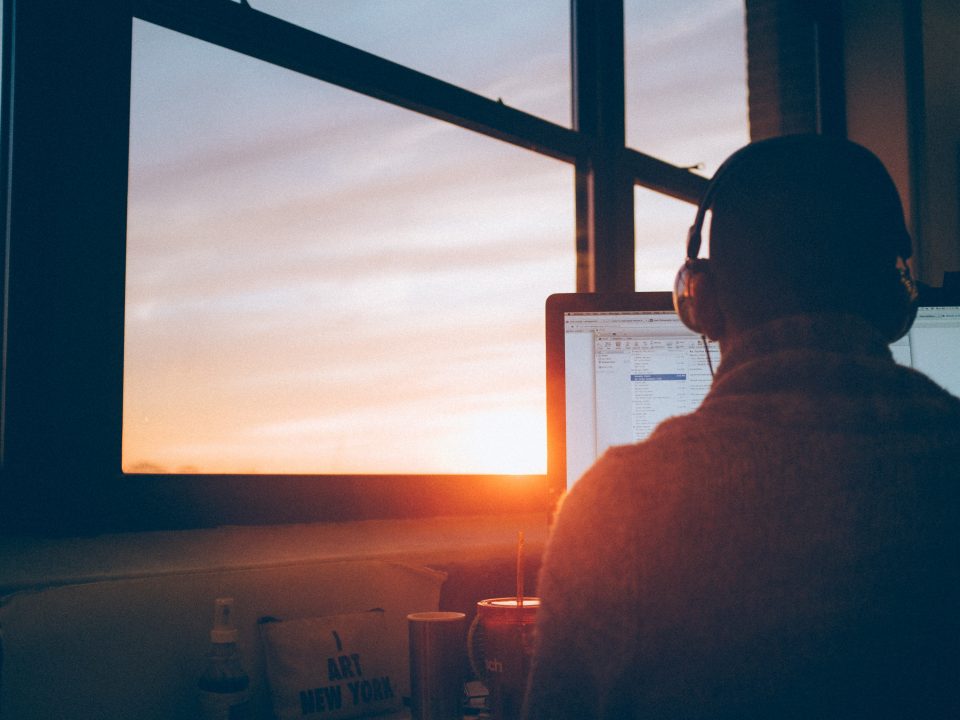 man sitting facing monitor