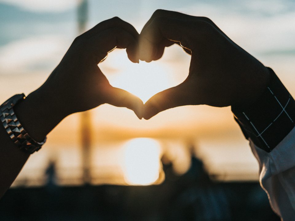 person forming heart with their hands