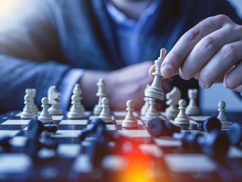 depth of field photography of man playing chess