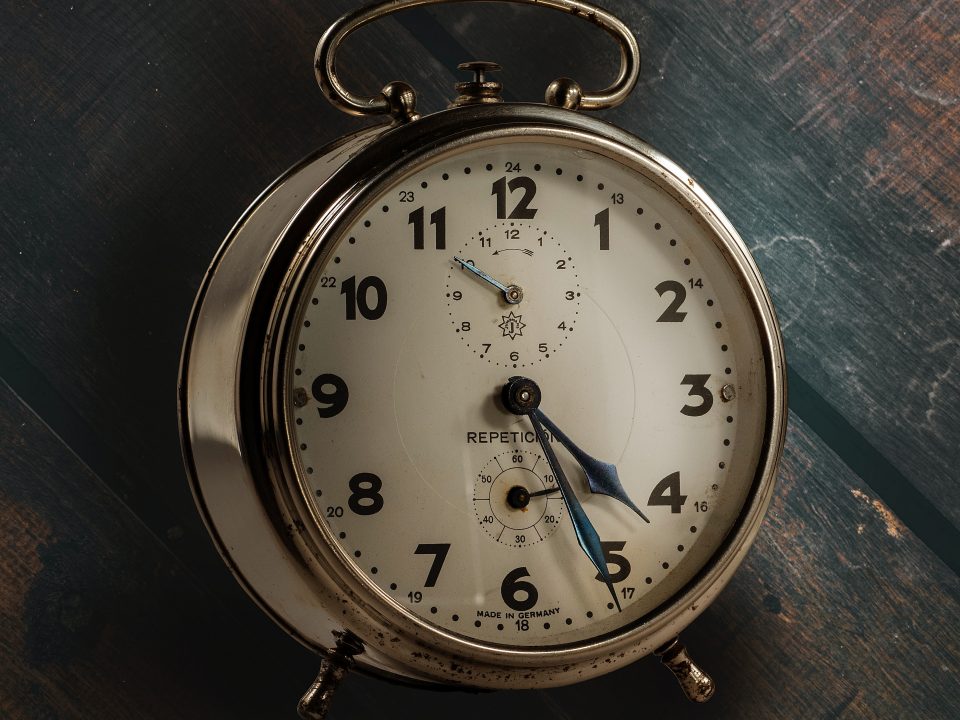 round silver and white analog desk clock pointing at 4:26