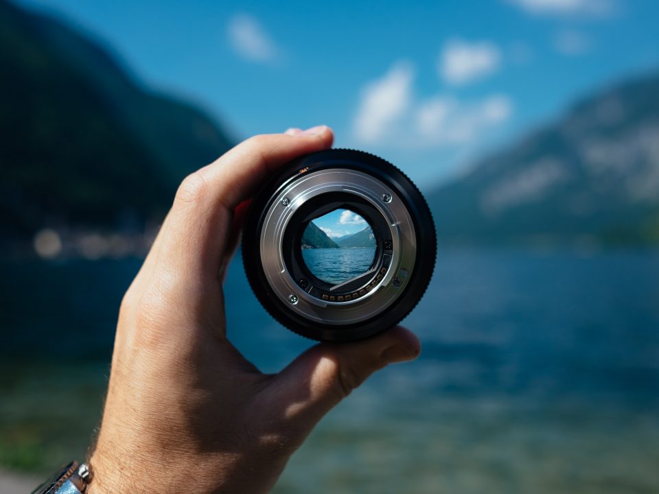 person holding camera lens