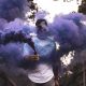 man holding purple smoke