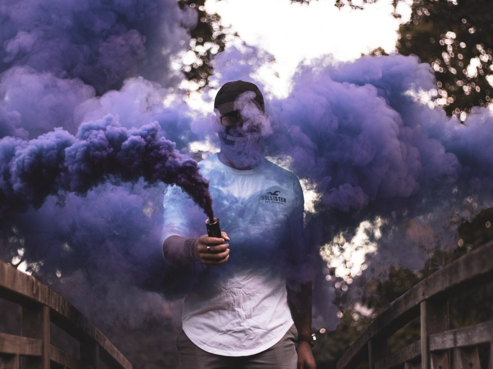 man holding purple smoke