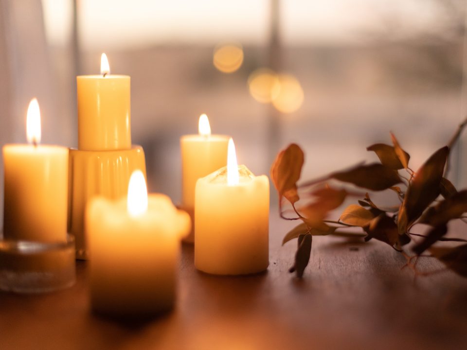 white pillar candles on brown wooden table