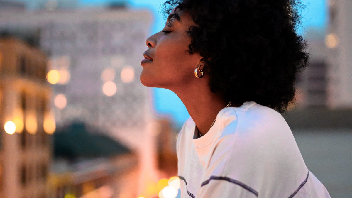 woman in white collared shirt looking at the city during night time