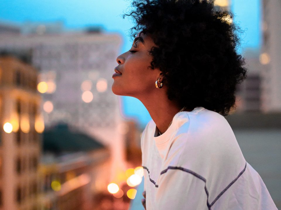 woman in white collared shirt looking at the city during night time