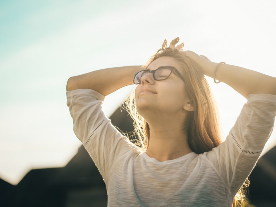 woman in white crew-neck T-shirt holding her head