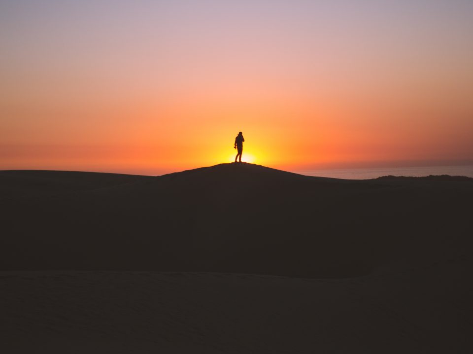 silhouette of person standing on hill