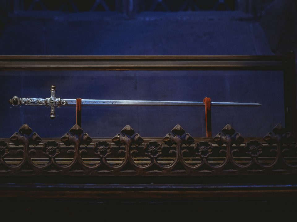 black and gold cross on black metal fence