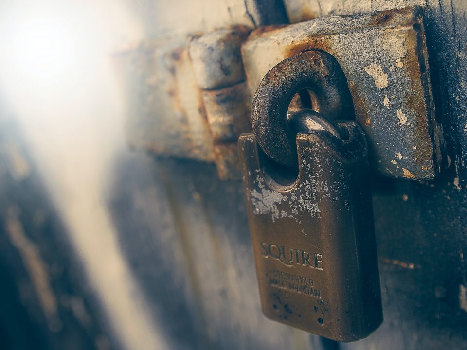 brown padlock in black wooden door