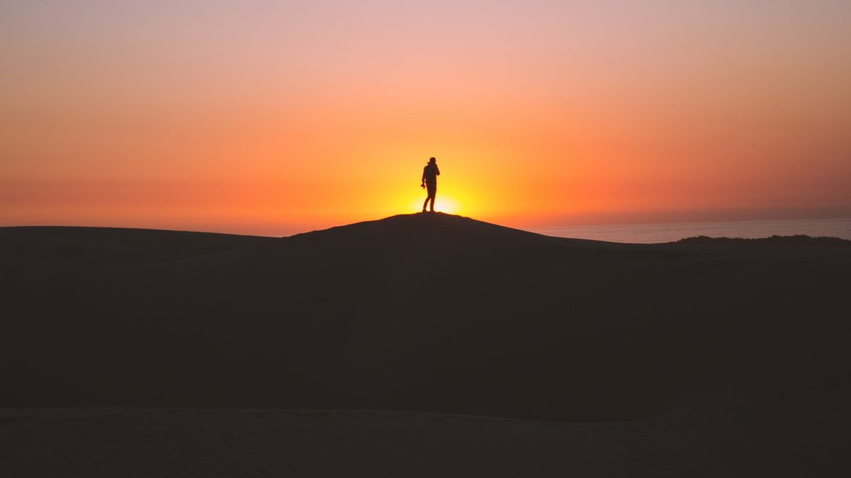 silhouette of person standing on hill