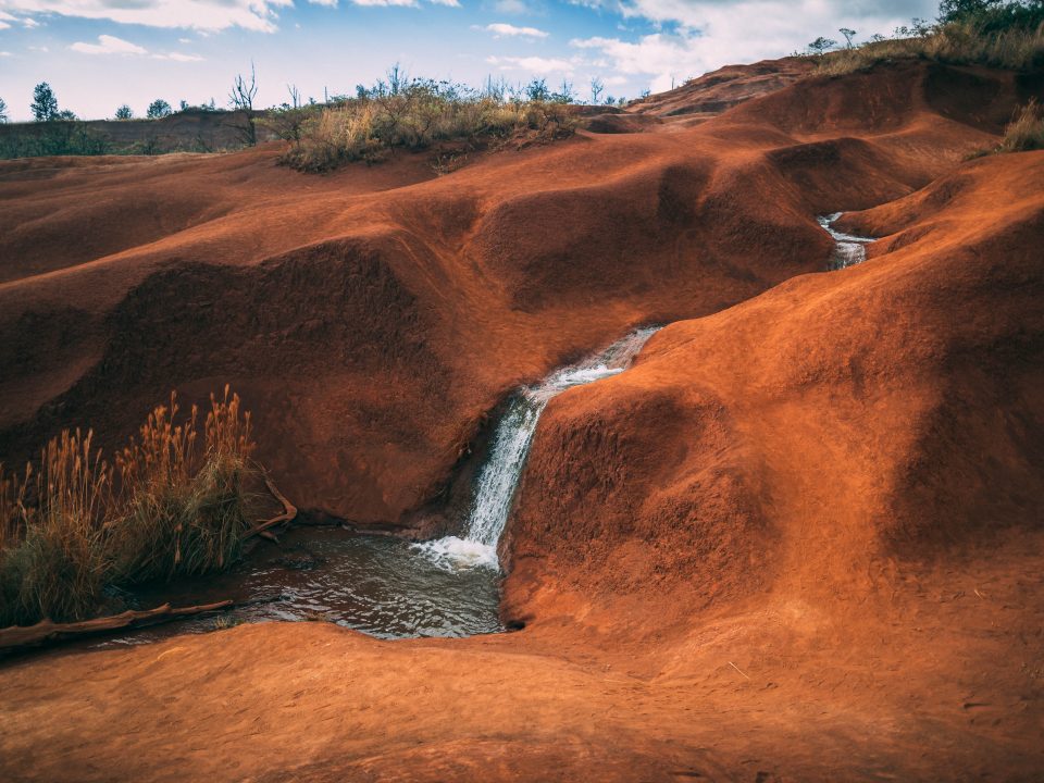 water flowing on brown hill