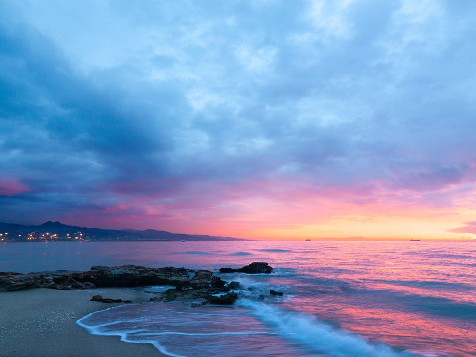 waves of body of water splashing on sand