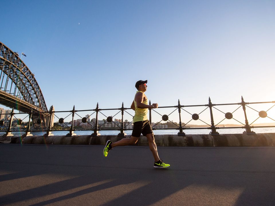 man in yellow tank top running near shore