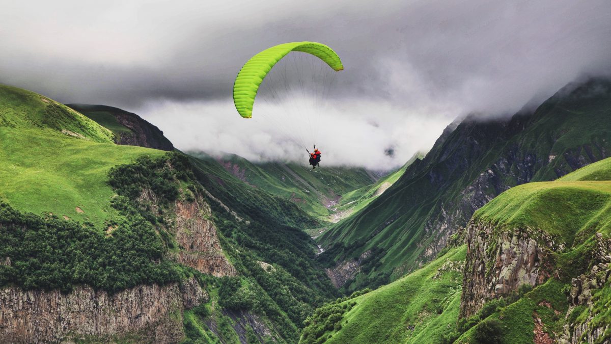 person paragliding near mountain range
