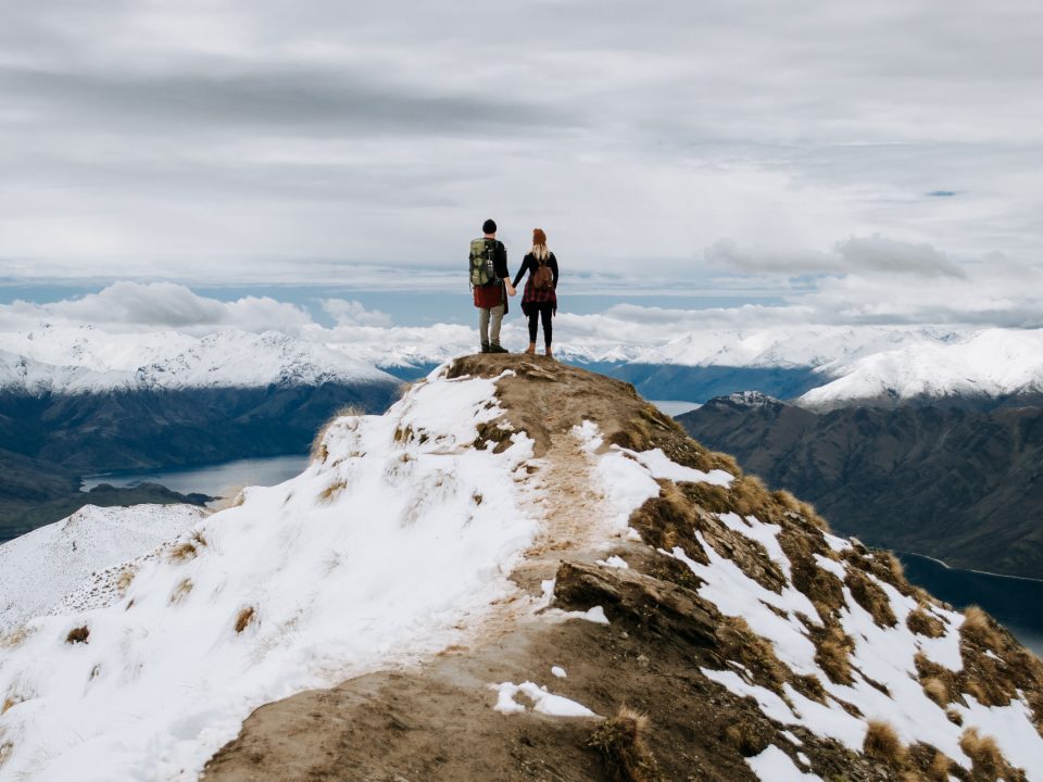 2 men standing on rocky mountain during daytime