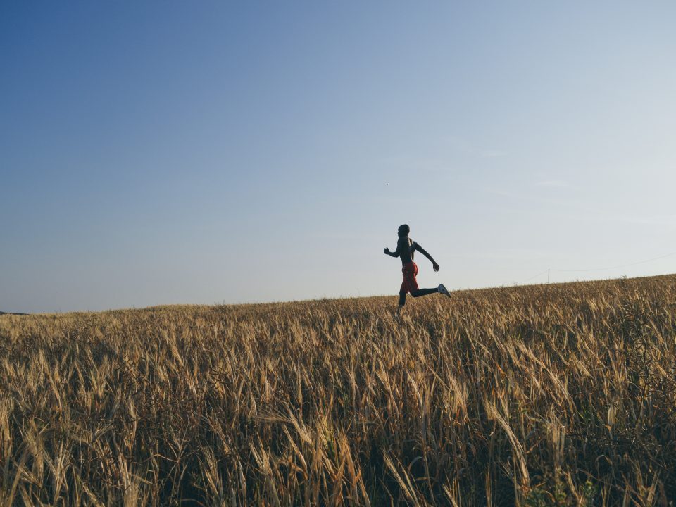 man in black jacket and black pants running on brown grass field during daytime