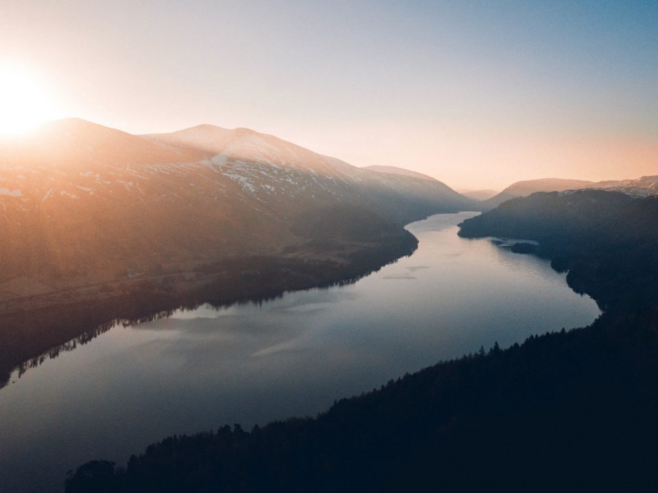 lake between trees and mountains