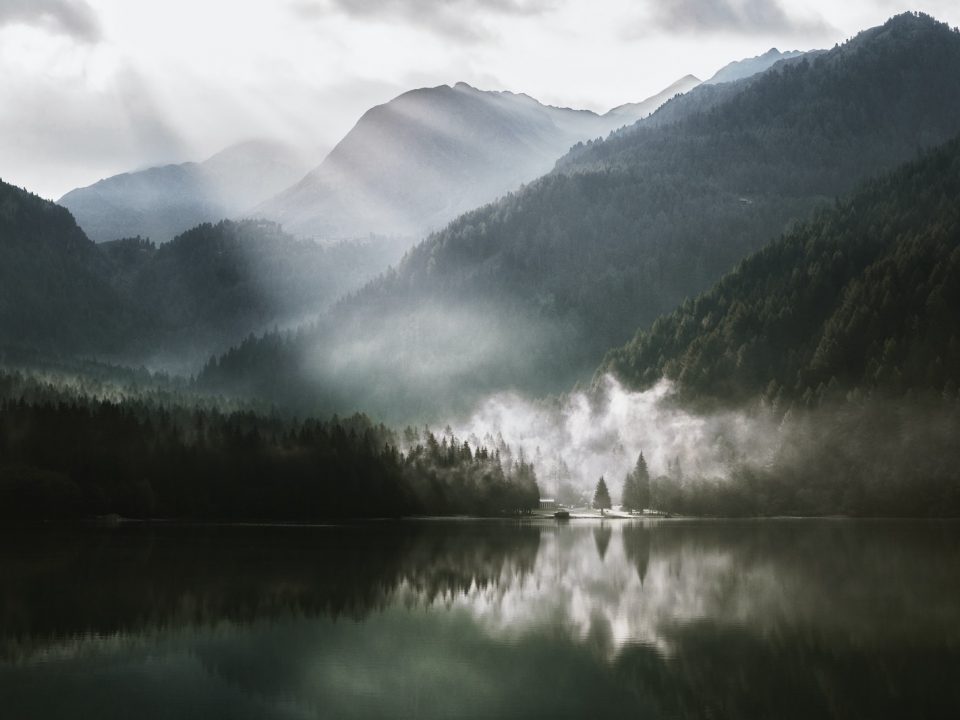 mountain across lake under white sky