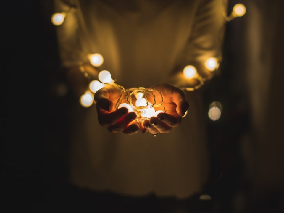 person holding string lights