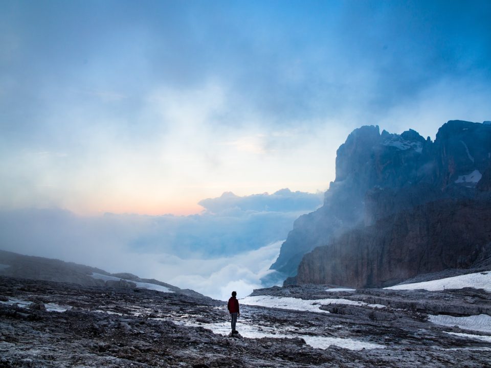 person standing near the cliff of the mountain