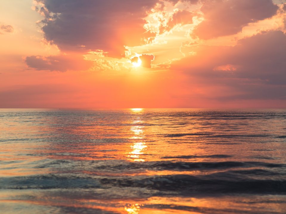 sea under white clouds at golden hour