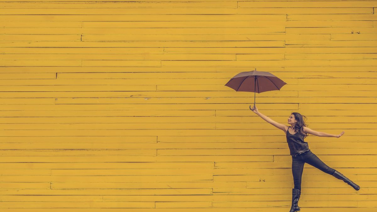 woman holding brown umbrella