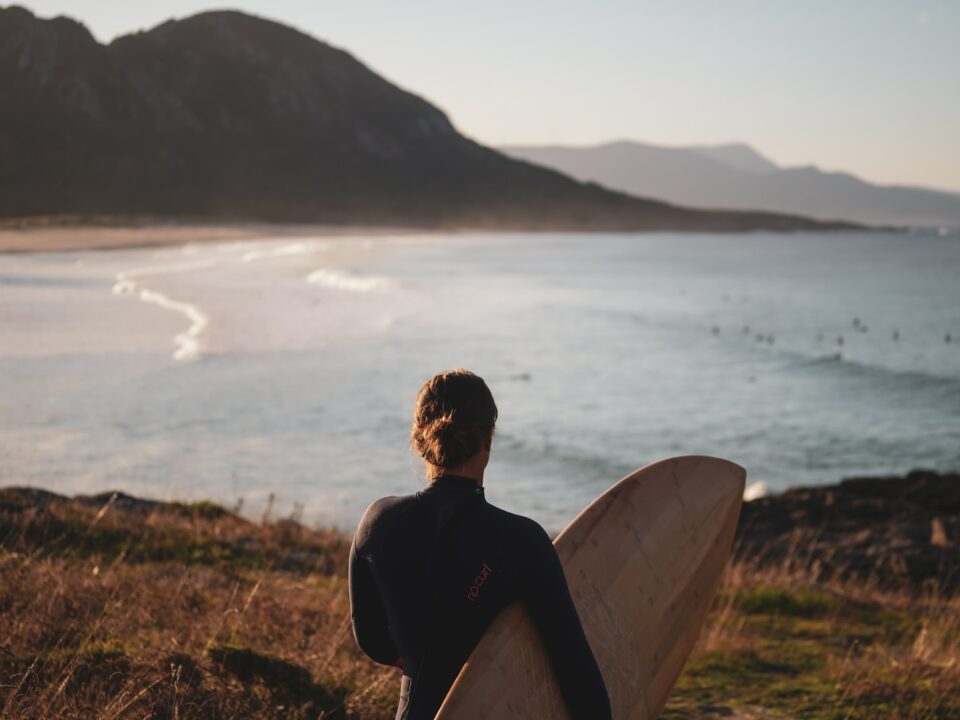 a man holding a surfboard looking out at the ocean