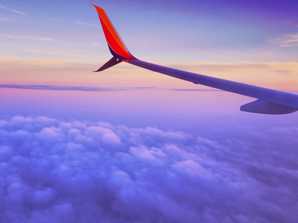 person in a plane flying at high altitude taking photo of left airplane wing during daytime