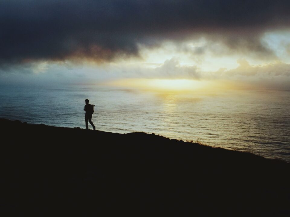 person walking beside body of water