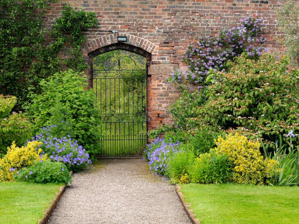 a garden with a brick wall and a gate
