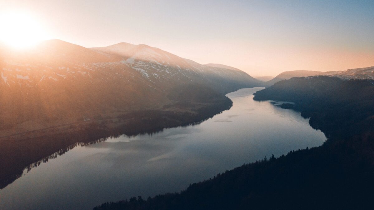 lake between trees and mountains