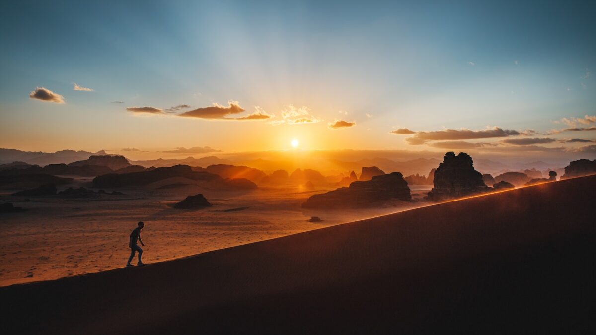 a person standing on top of a sandy hill