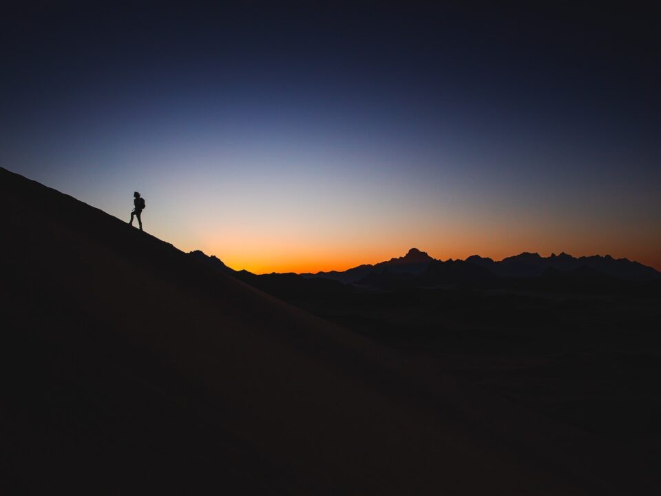 a person standing on top of a mountain at sunset