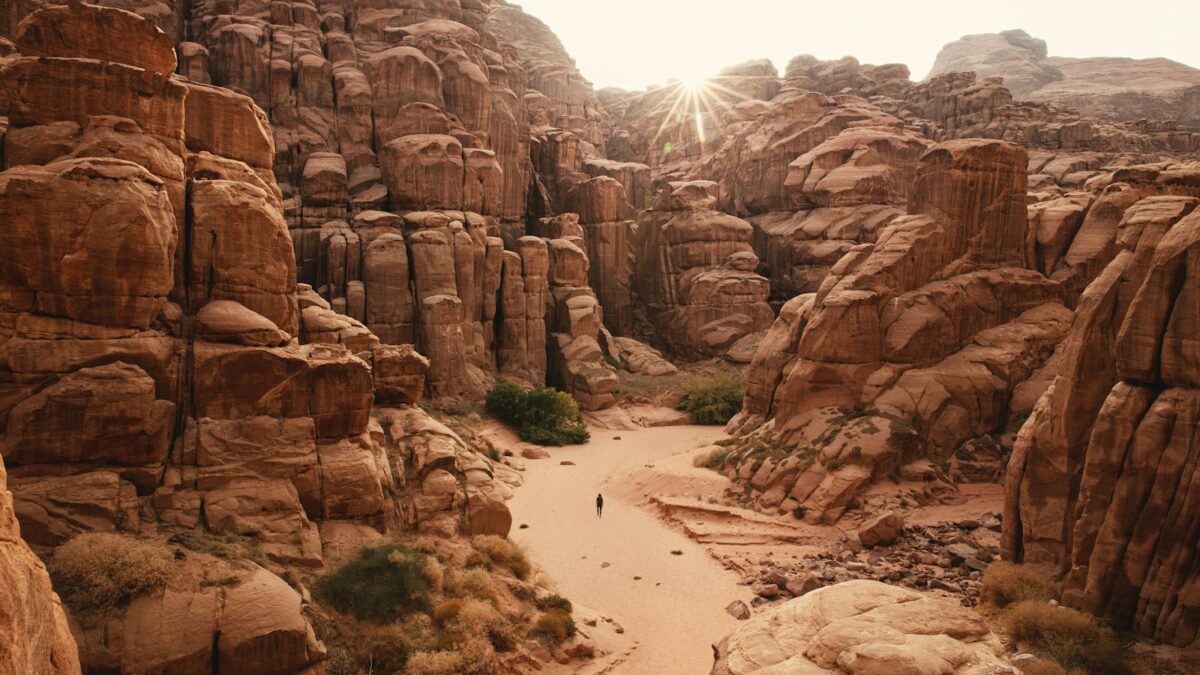 a person walking through a canyon in the desert