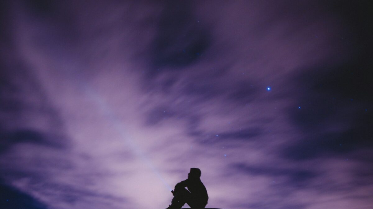 person sitting on black surface looking to sky