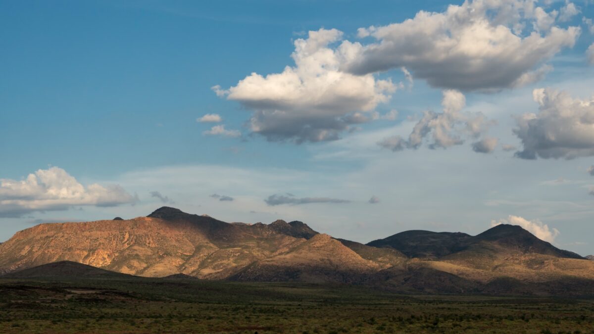 a mountain range with a few clouds in the sky