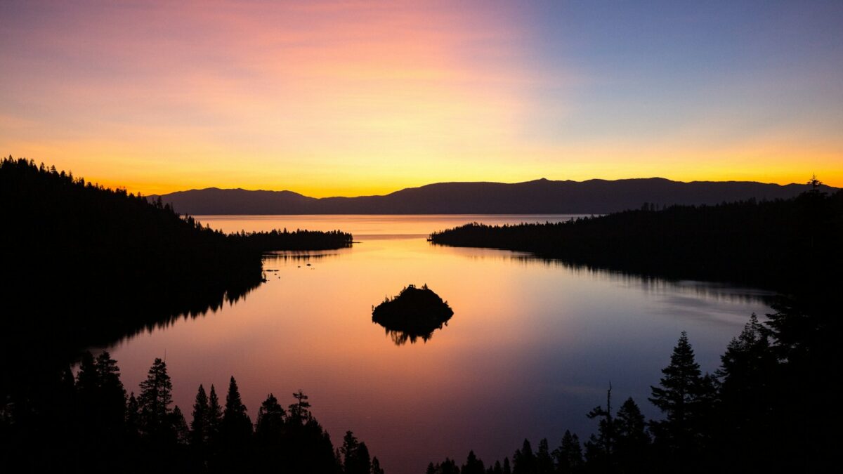 silhouette of trees and mountain near body of water