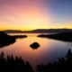 silhouette of trees and mountain near body of water