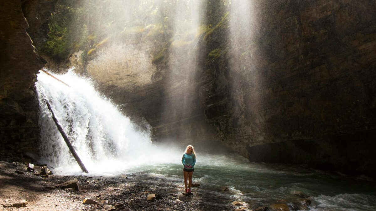 woman standing near river under gray sky during daytime