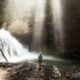 woman standing near river under gray sky during daytime