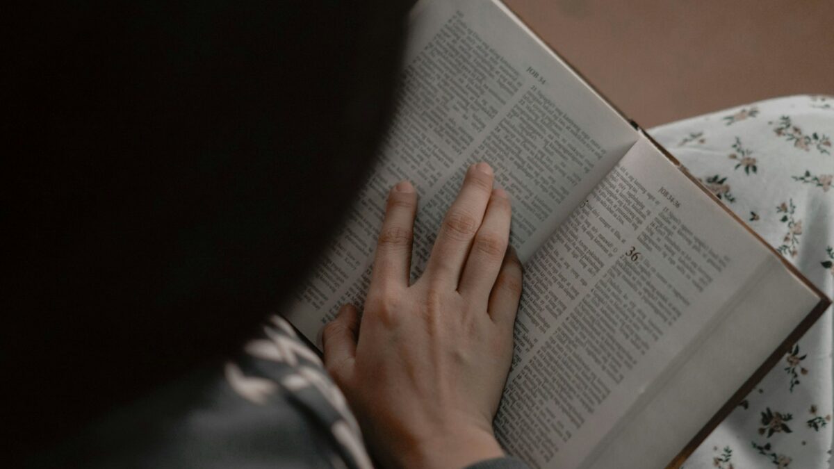 a person reading a book on a bed