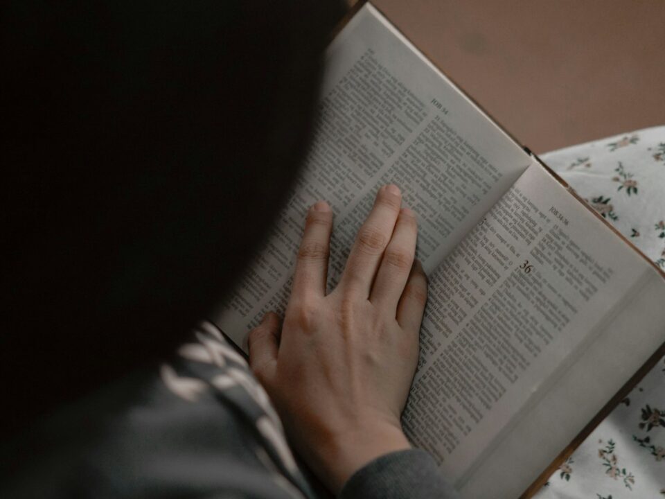 a person reading a book on a bed