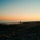 person on seashore during golden hour