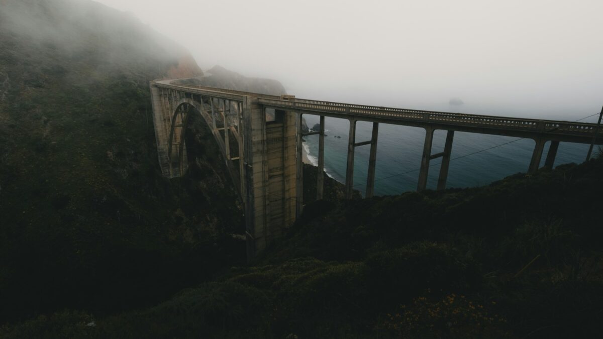 A foggy mountain with a bridge in the foreground