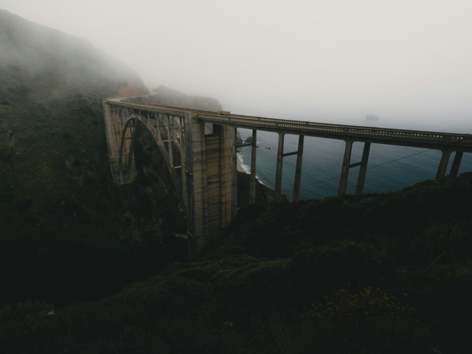 A foggy mountain with a bridge in the foreground