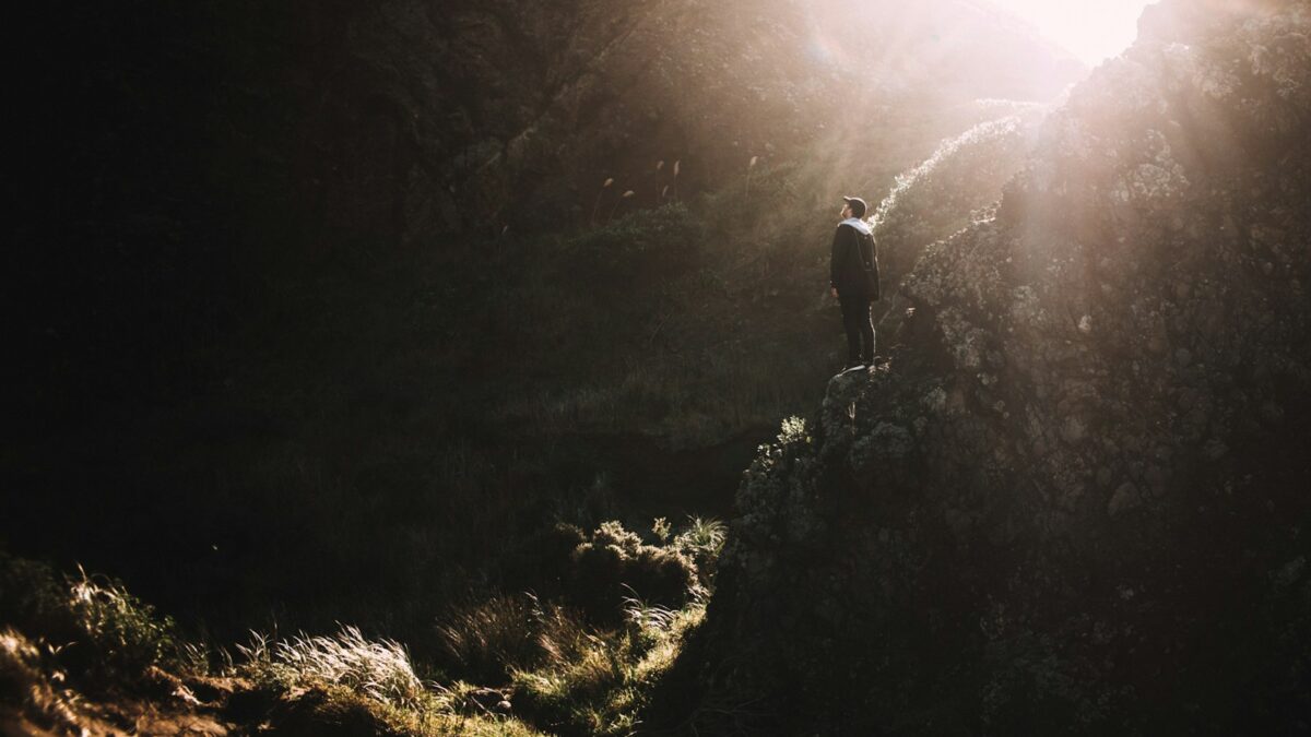 man standing on rock mountain during daytime