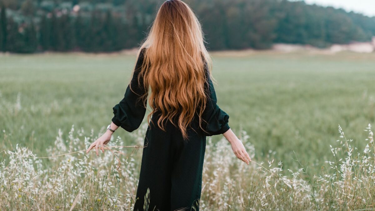 woman standing on green grass field during daytime