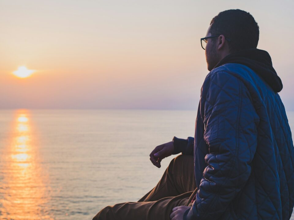 man sitting near body of water